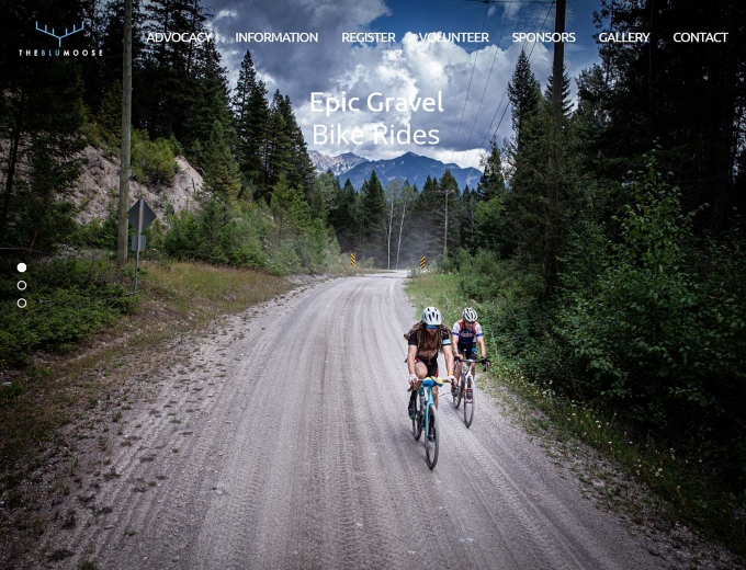 Cyclists on a track road in mountains on website home page